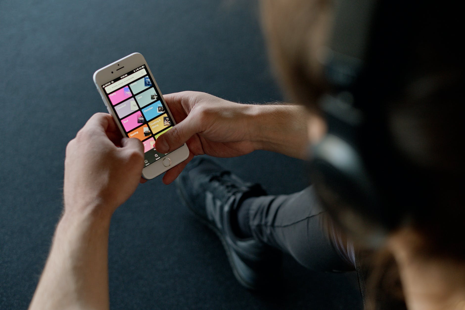 person with headphones holding a smartphone